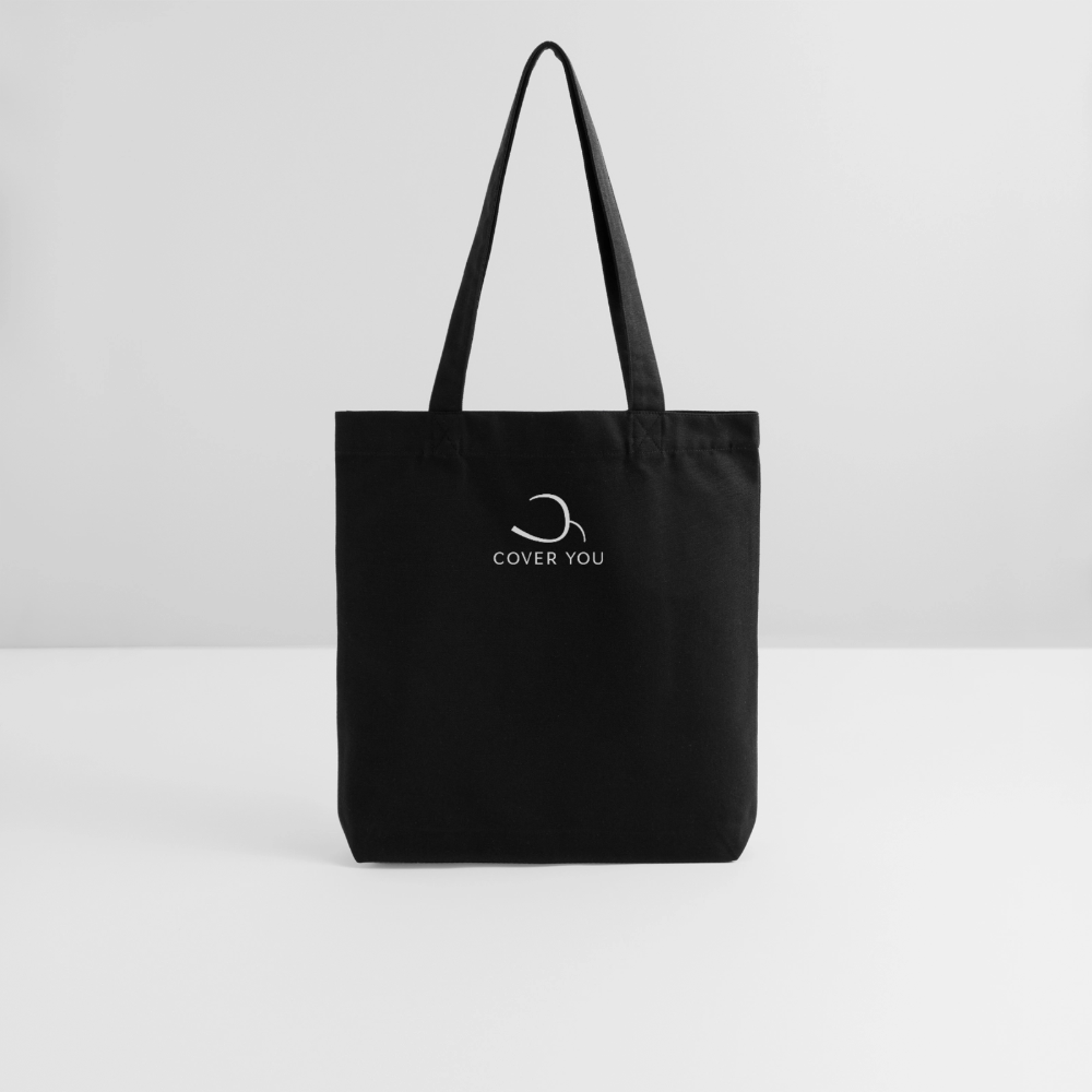 Tote bag COVER YOU noir posé sur fond clair, longues anses relevées